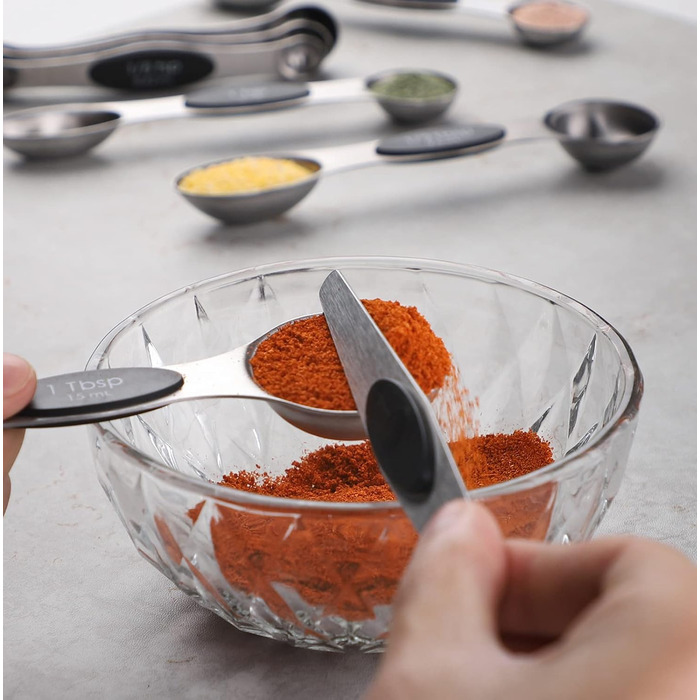 Measuring cup and spoon set includes 5 stainless steel measuring cups, 7 magnetic measuring spoons, and 1 leveler for dry or liquid ingredients (black)